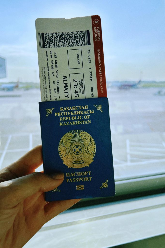 Kazakhstan passport with boarding pass in Warsaw airport, ready for travel.
